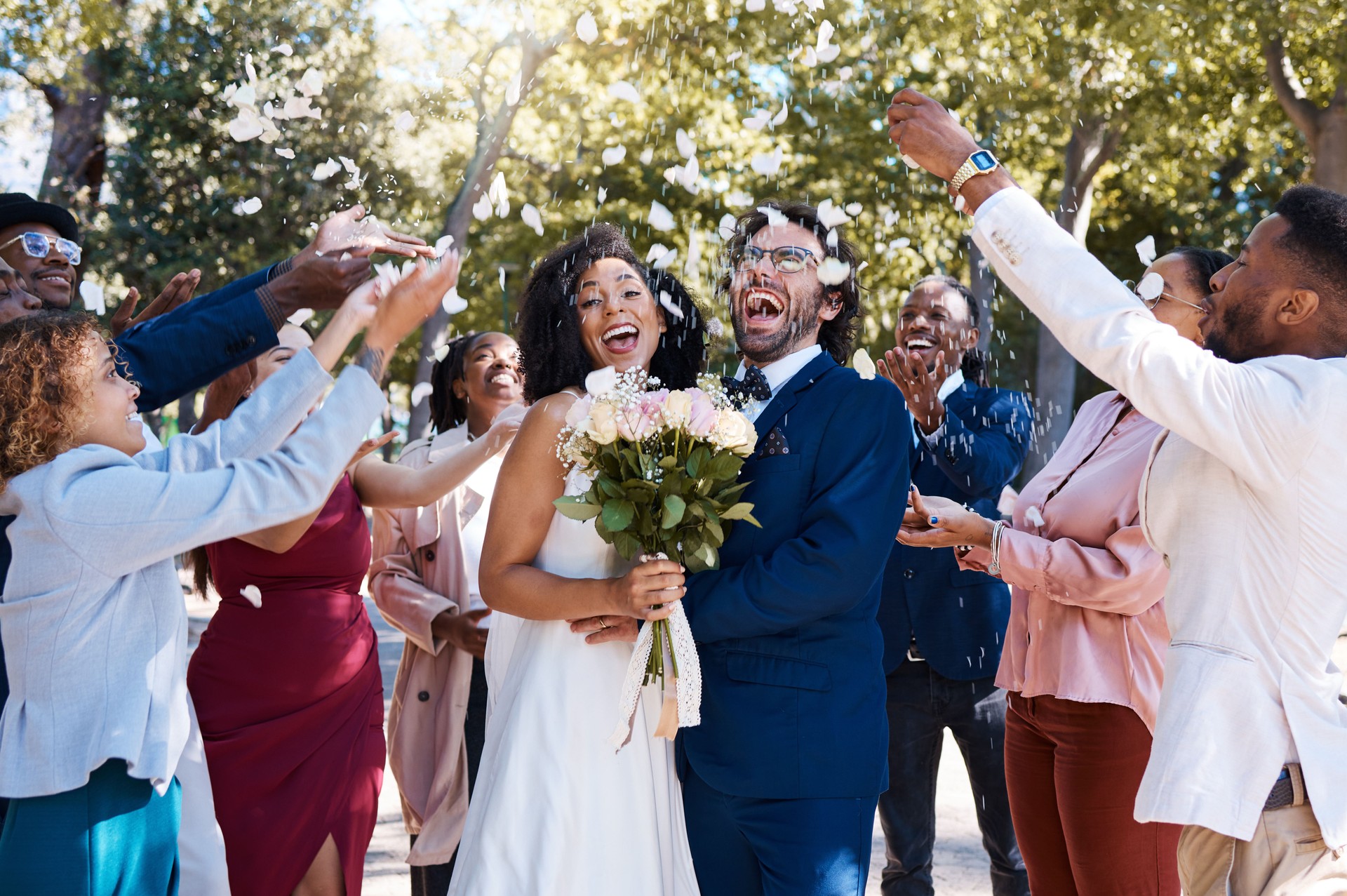 Wedding confetti, marriage couple and celebration of audience throwing flower petals outdoor. Happiness, excited and social event with bride and man laughing from love and congratulations applause